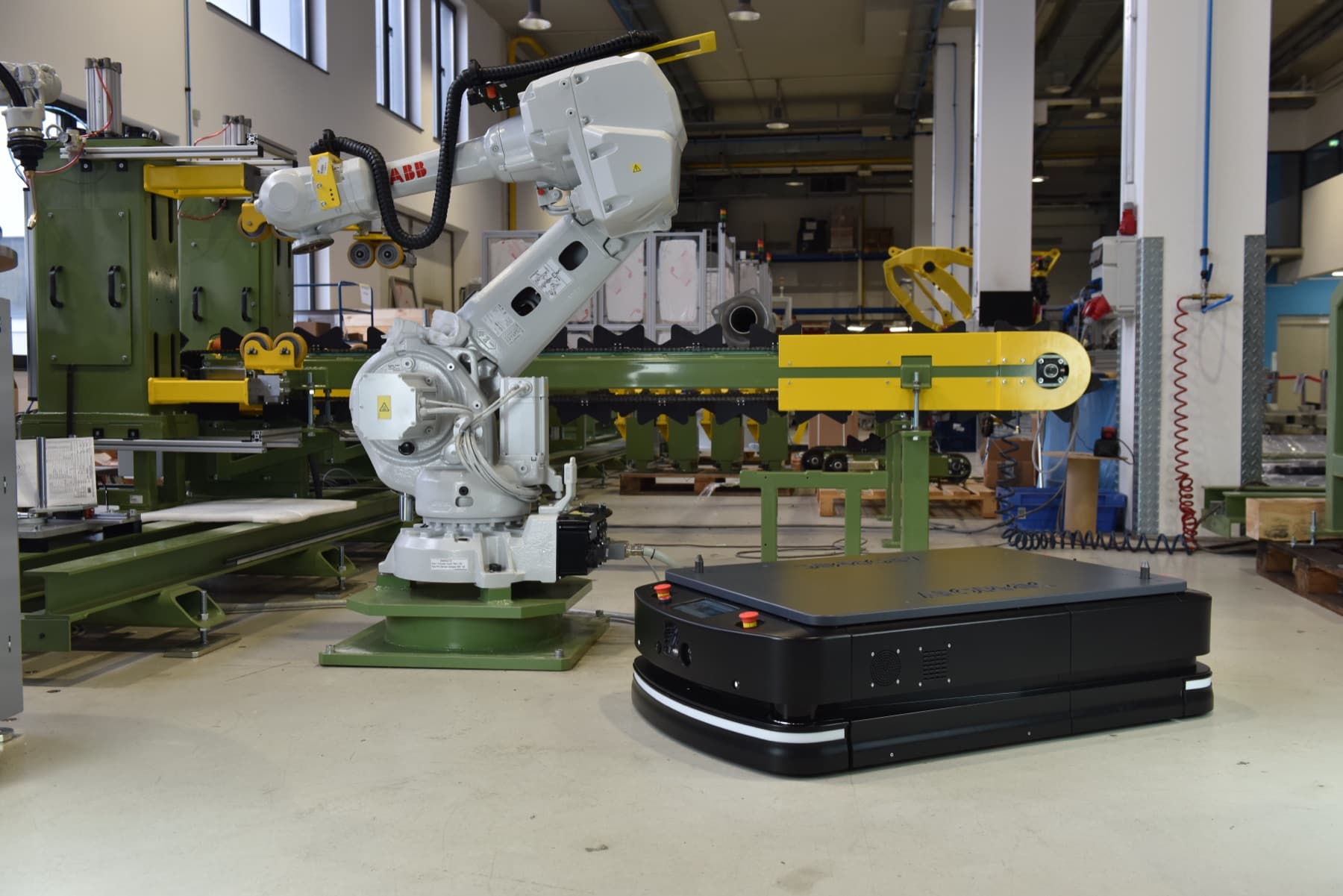 Autonomous mobile robot operating in a working warehouse alongside staff