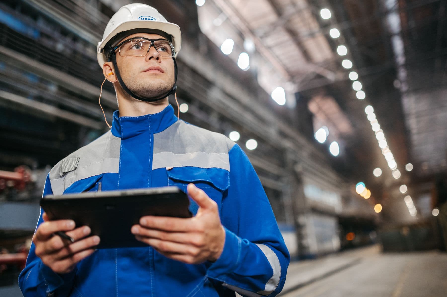 Onsite technician coordinating with a remote support team by phone beside equipment